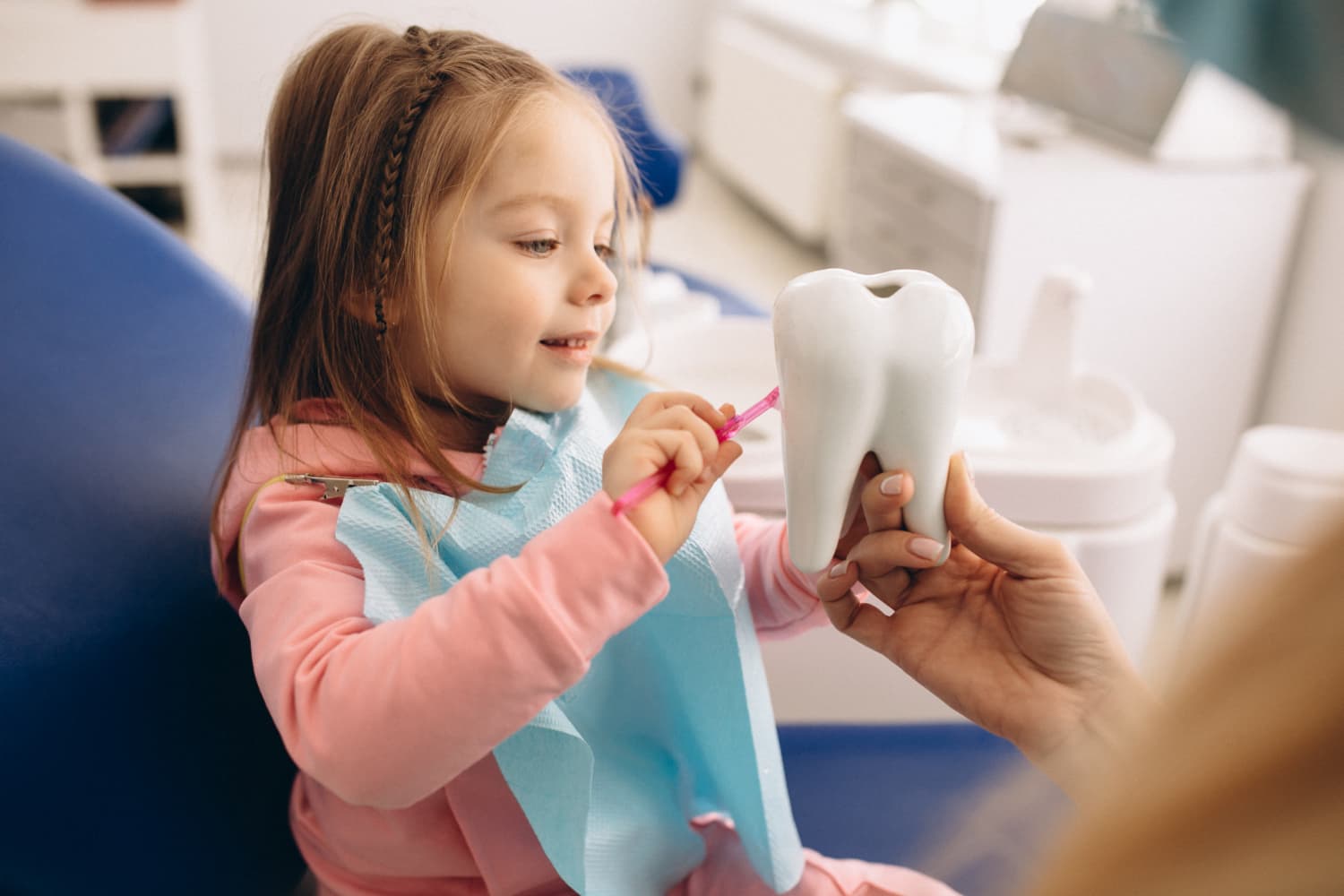 Bambina dal dentista impara a lavarsi i denti con il fluoro