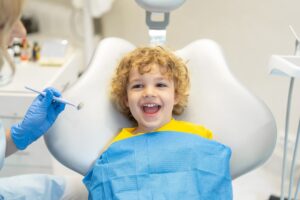 Bambino sorridente seduto sulla poltrona del dentista