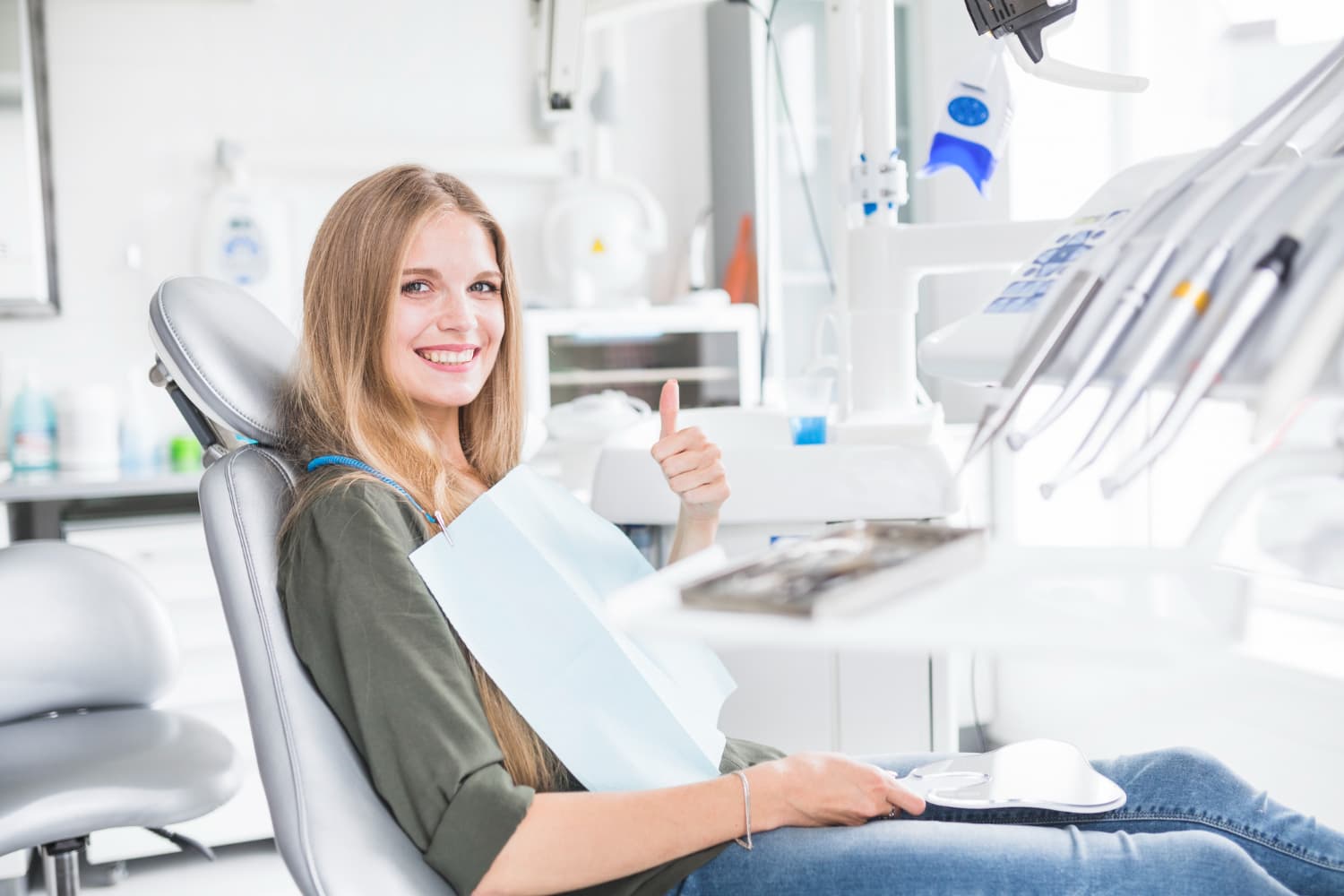 Ragazza sorride seduta sulla poltrona del dentista